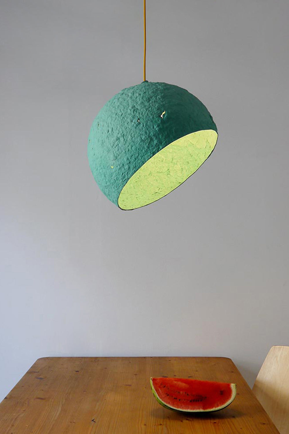 hanging lamp globe made of paper mache above the table with watermelon