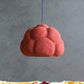 Light Sculpture Sensi in red made of paper mache above the table with apples