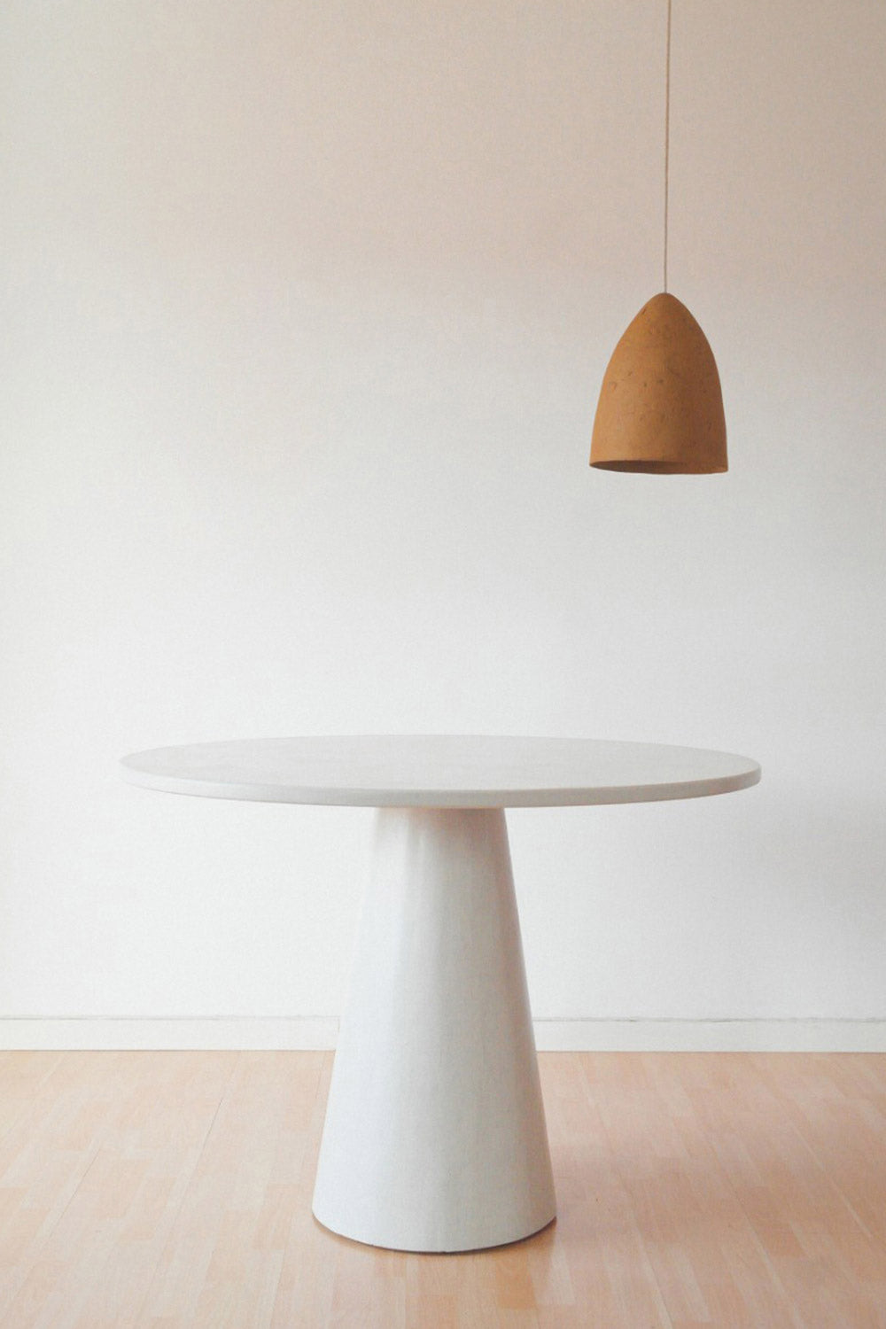 yellow paper mache light conica above the microcement table