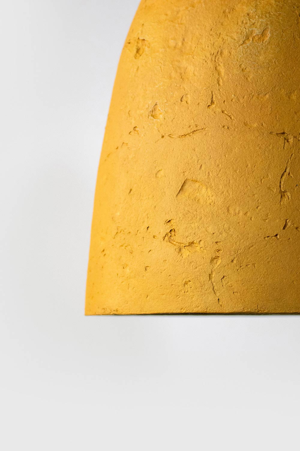 detail of the texture of yellow paper mache light conica